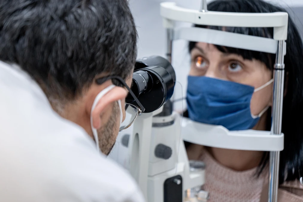 Optometrist and patient wearing masks