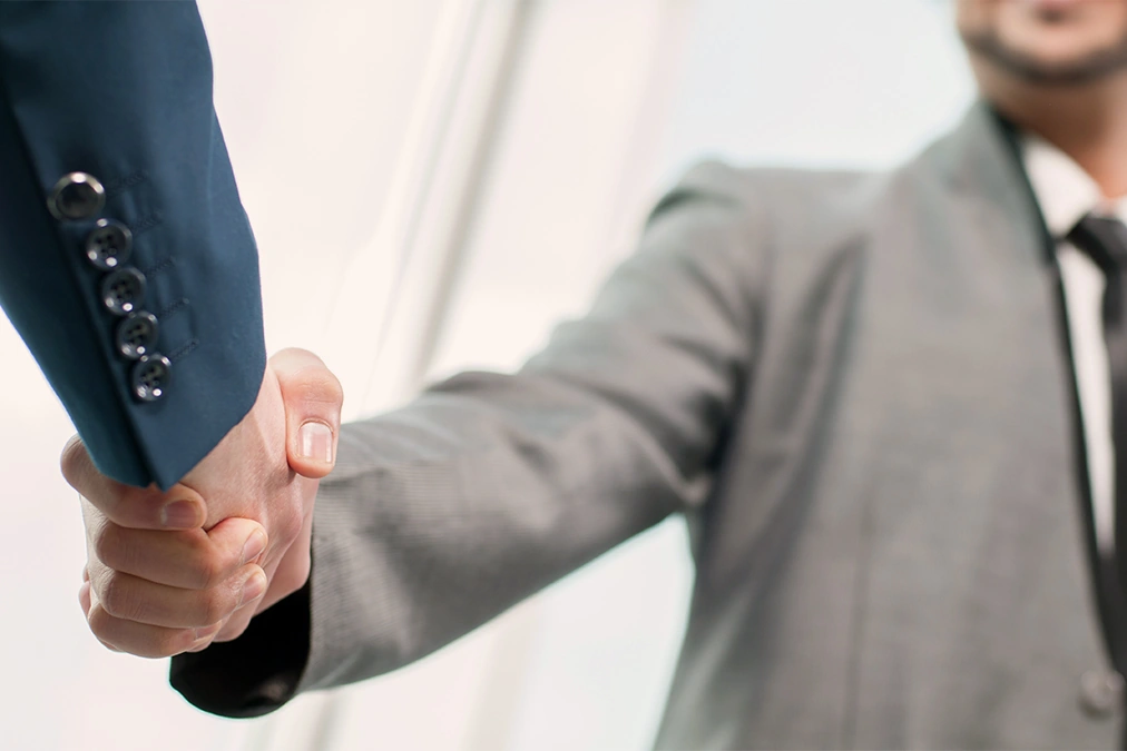 Men in suits shaking hands after promotion