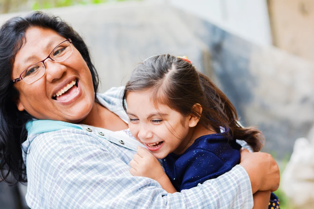 Happy mom wearing glasses and holding young daughter