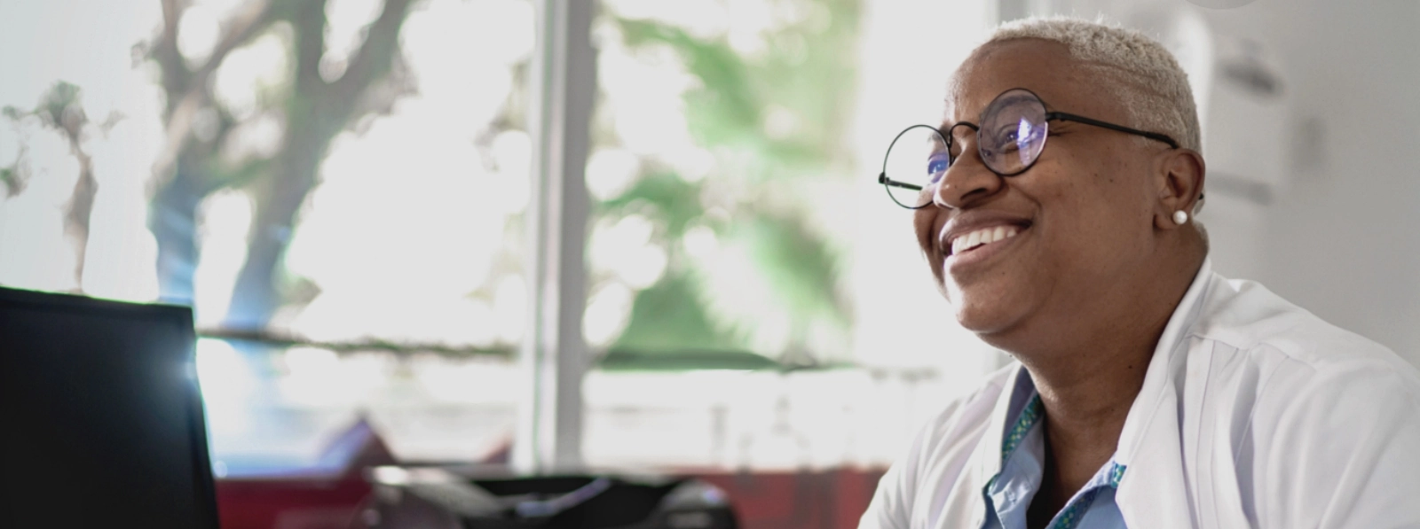 Black woman smiling sitting at her desk