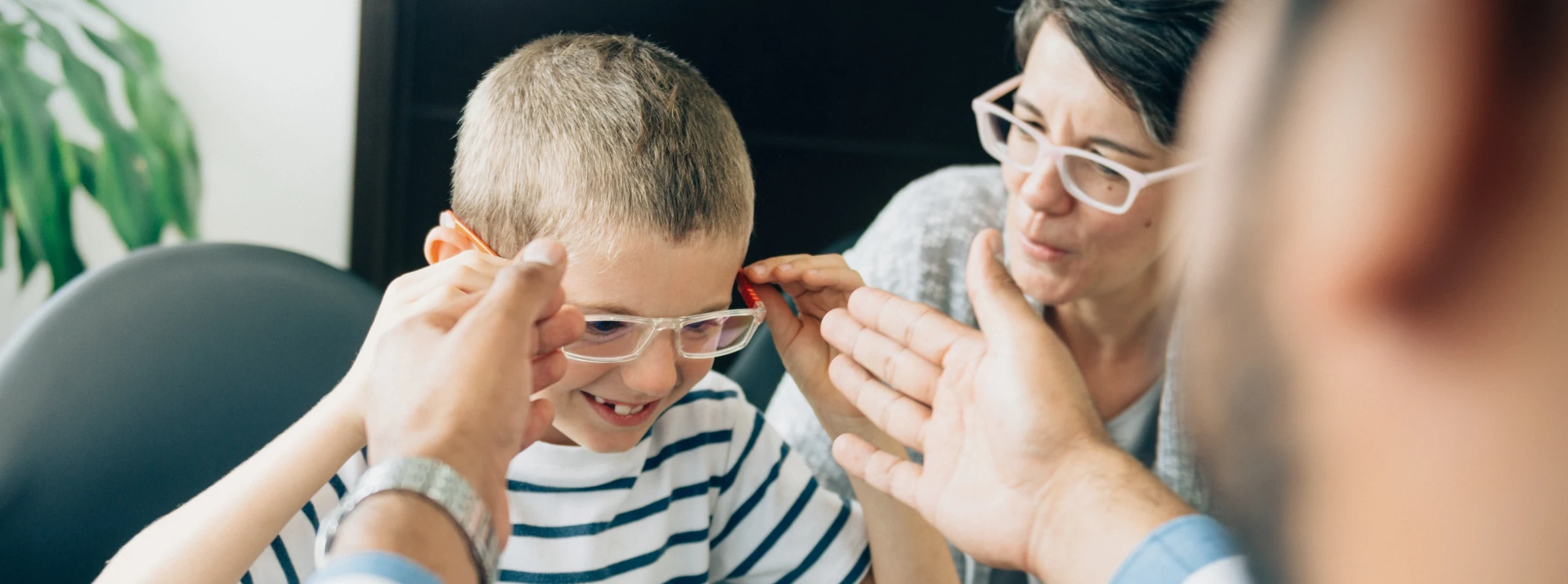 Young boy receiving glasses from doctor