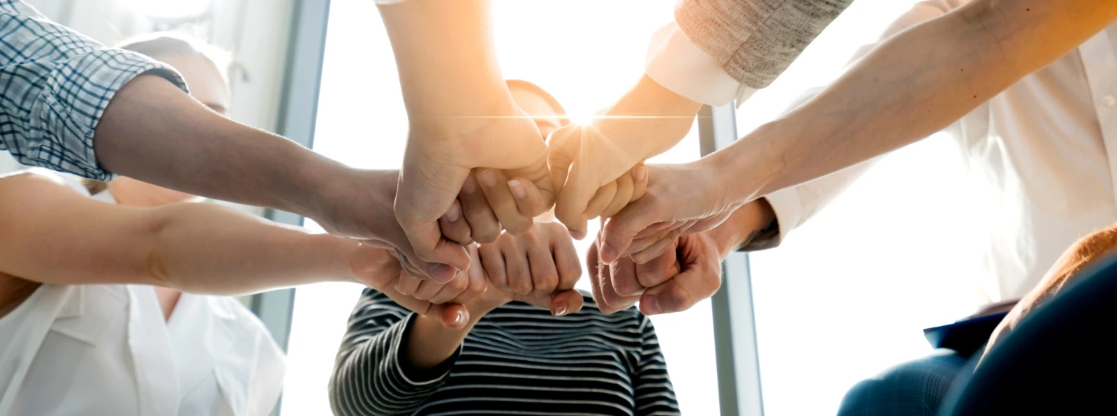 Team of people putting their hands together